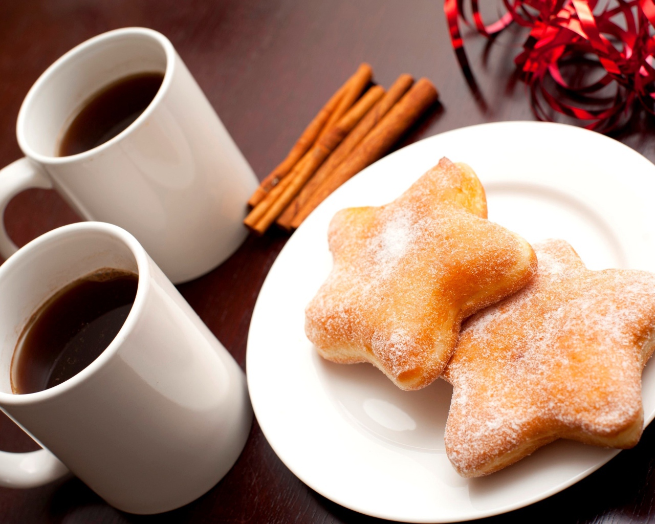Пончики на столе с кофе и палочками корицы