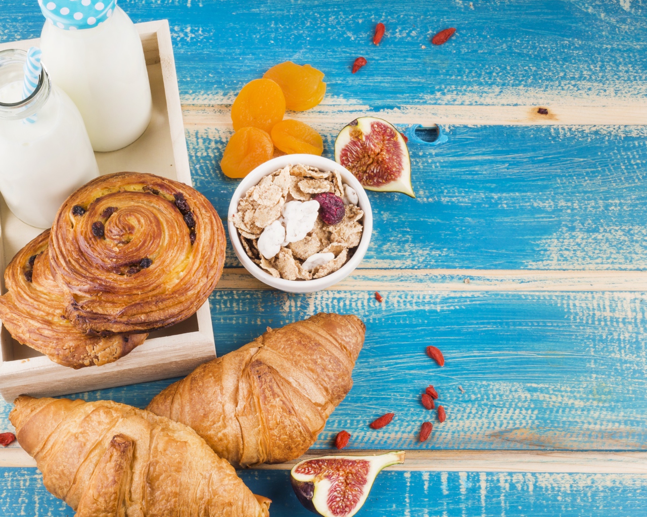 Свежая выпечка, молоко и мюсли на завтрак на столе