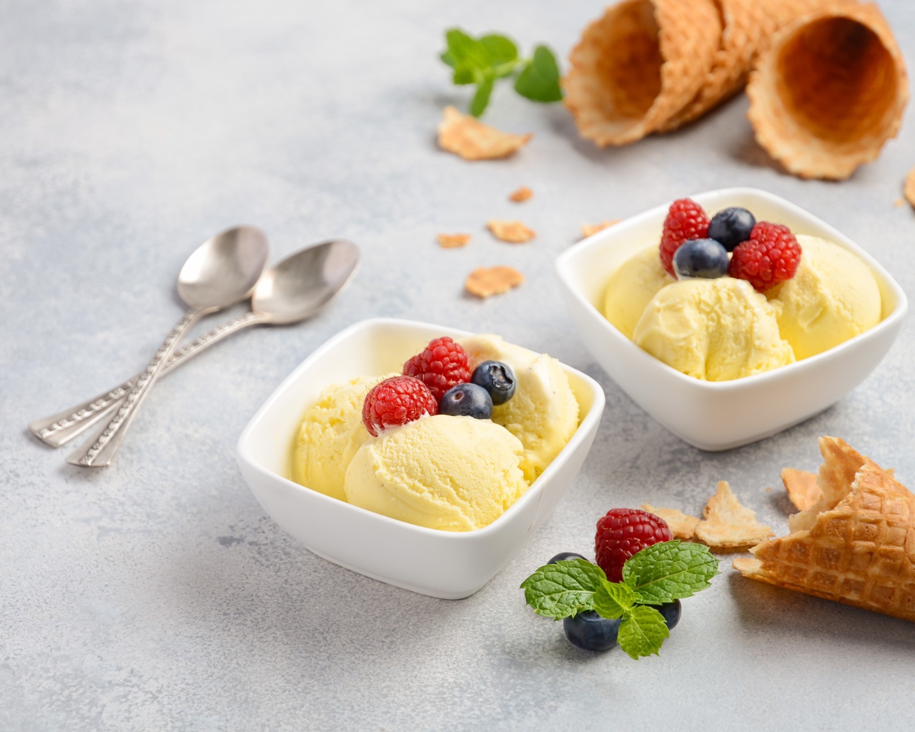 Шарики мороженого с ягодами на столе с вафельными рожками