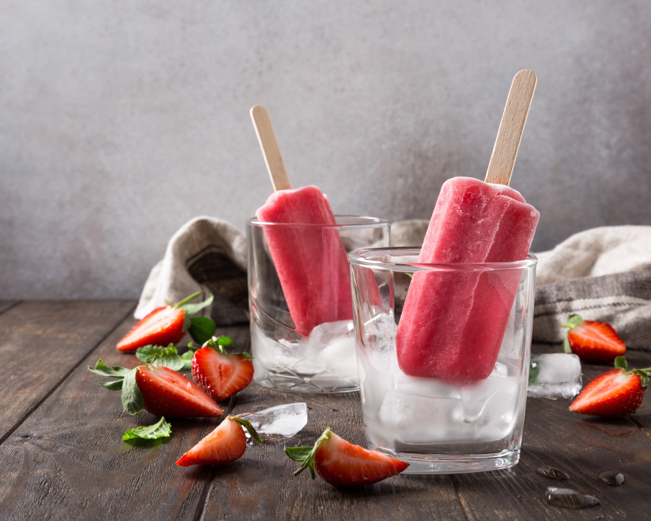 Фруктовое мороженое в стакане со льдом на столе с клубникой