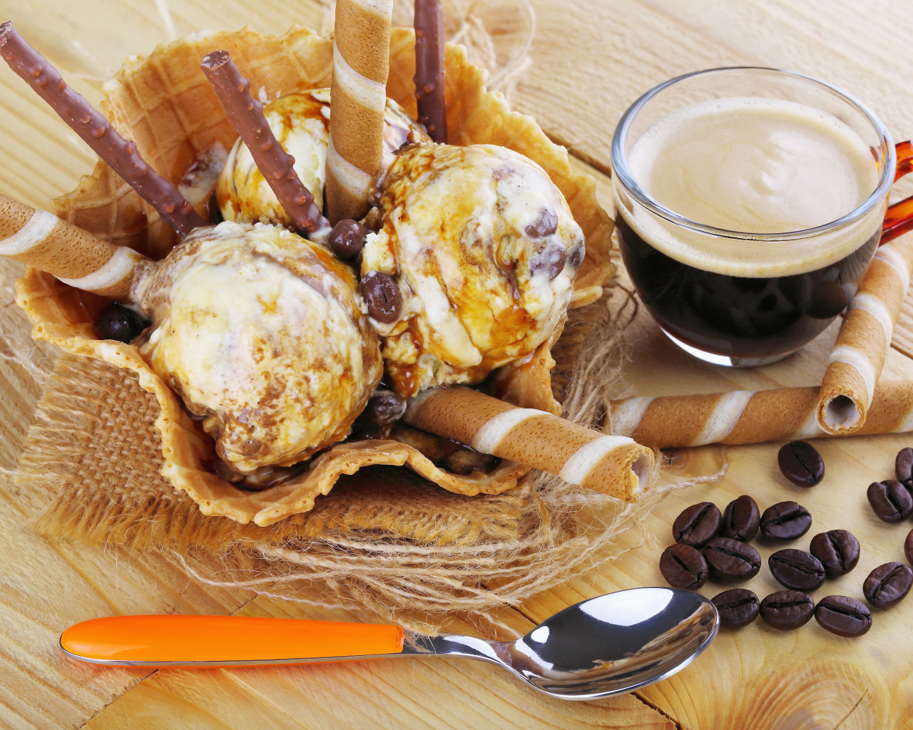 Мороженое с трубочками на столе с кофейными зернами и кофе