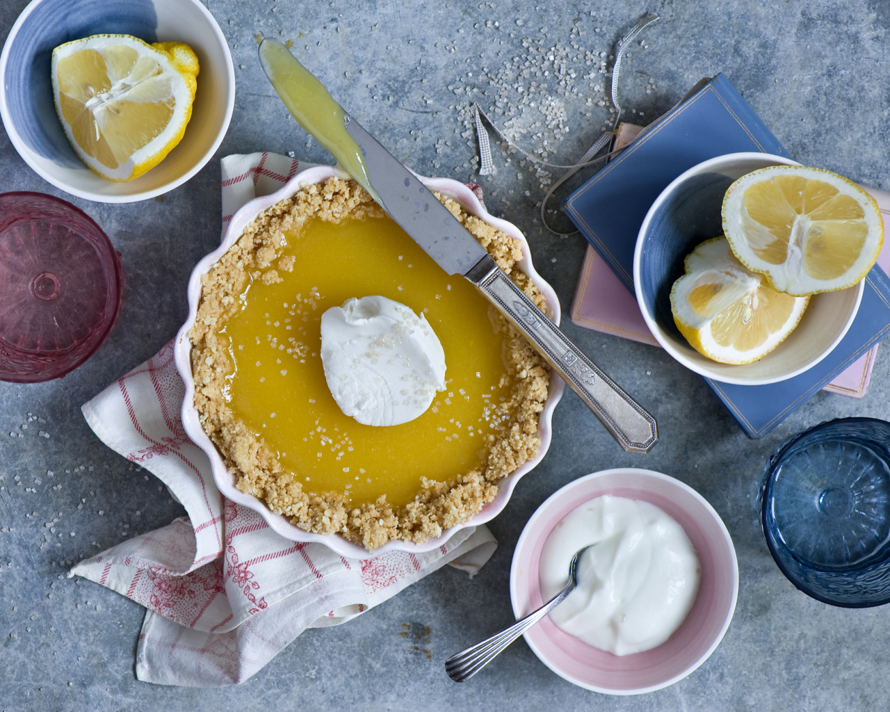 Лимонный пирог на столе с лимонами и сметаной