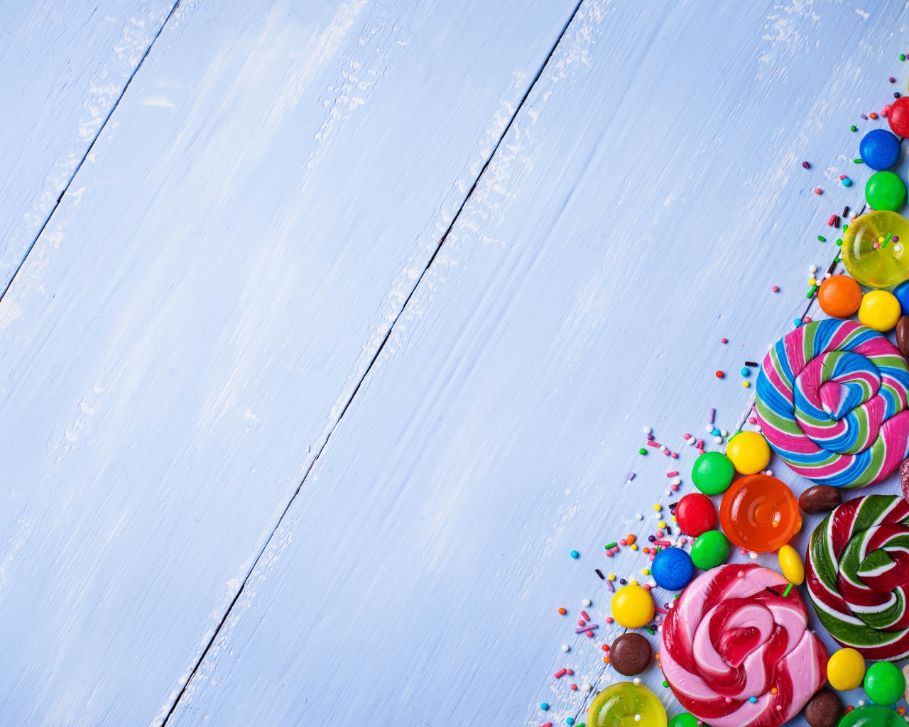 Разноцветные конфеты на голубом столе