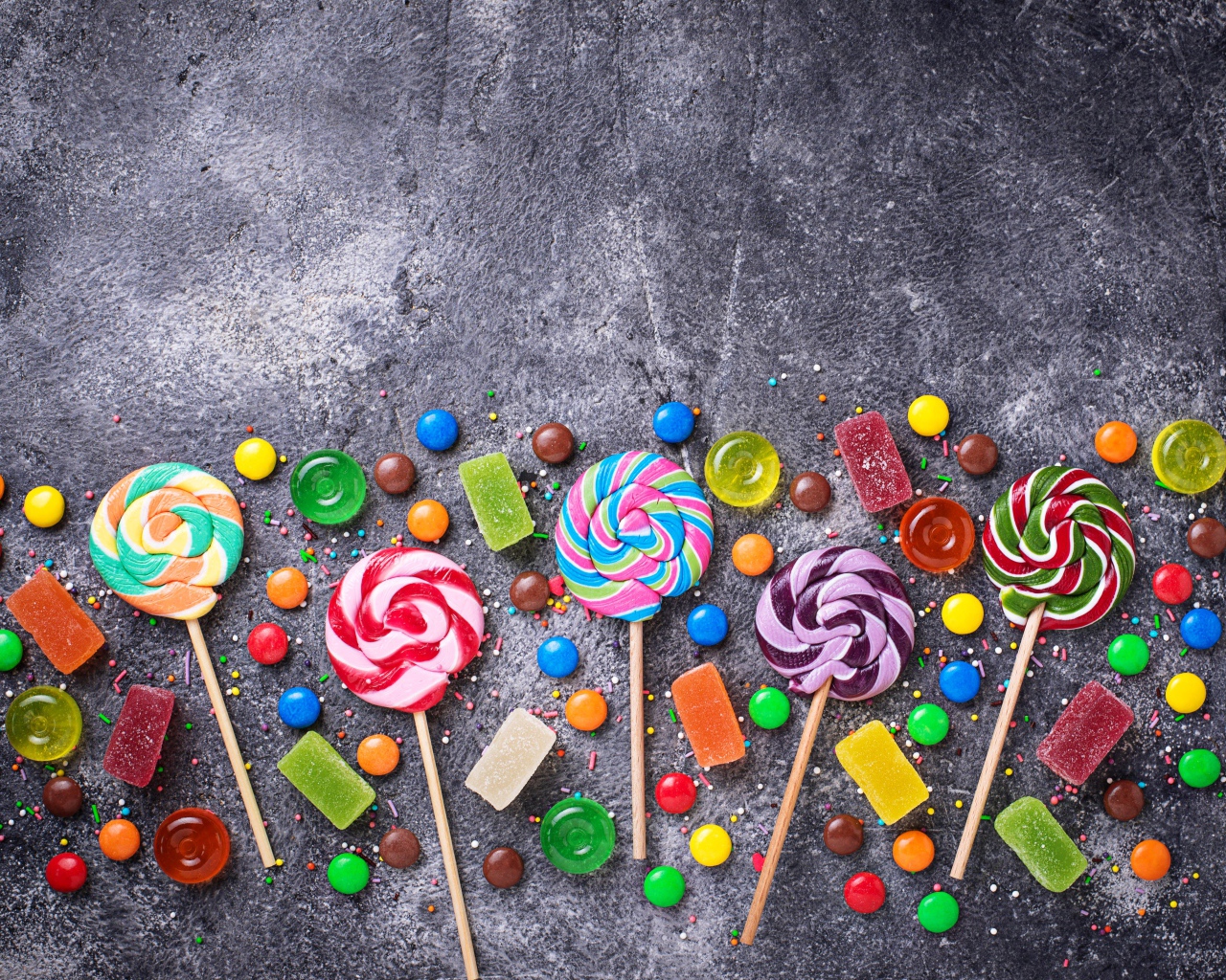 Разноцветные леденцы на сером столе