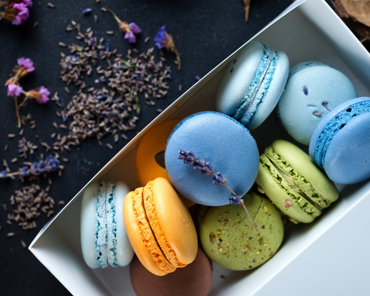 Разноцветный десерт макарон в коробке на столе с лавандой