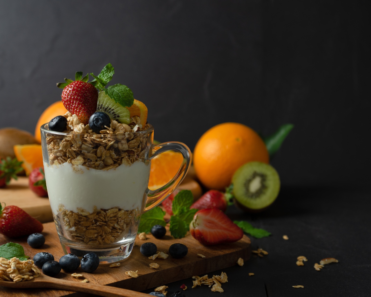 Овсяные хлопья с чашке с йогуртом на столе с ягодами и фруктами