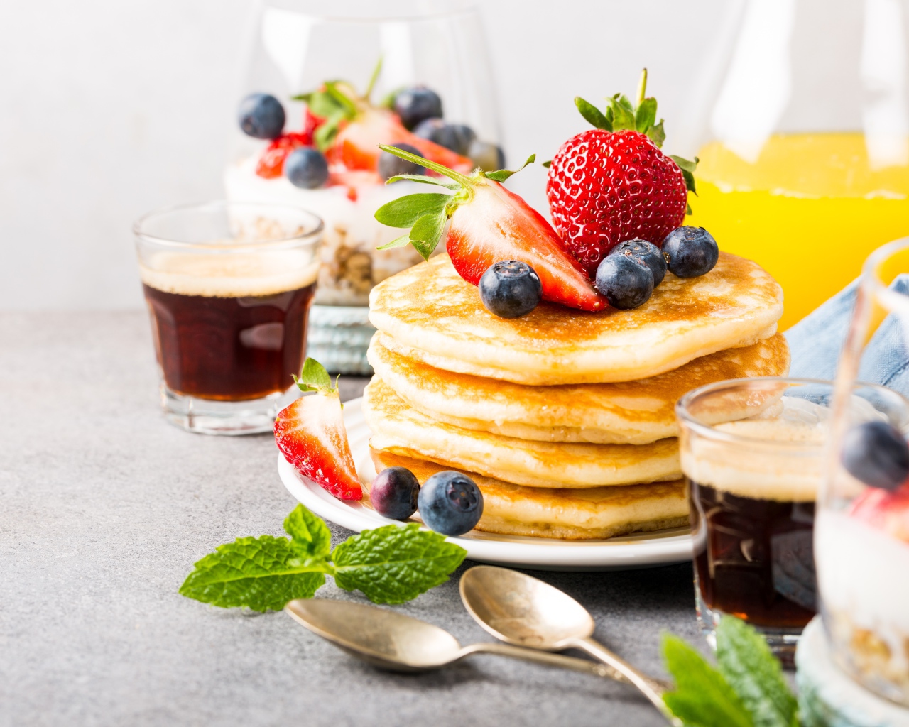 Оладьи с ягодами на столе с соком