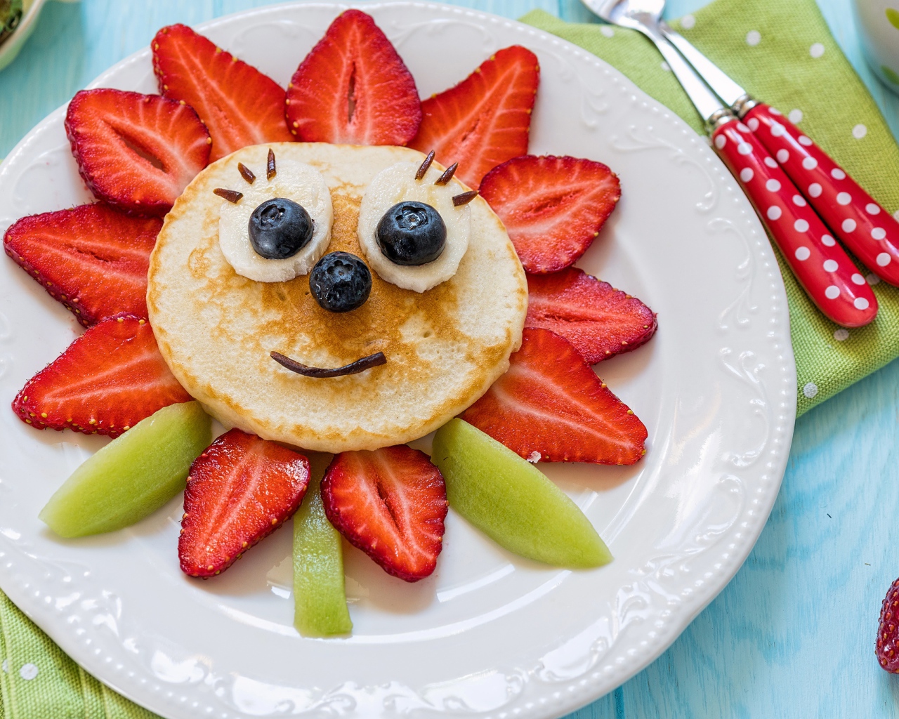 Оладьи с фруктами и ягодами на тарелке