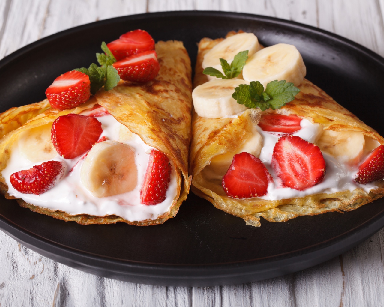 Блинчики со сметаной, бананами и клубникой на сковороде 