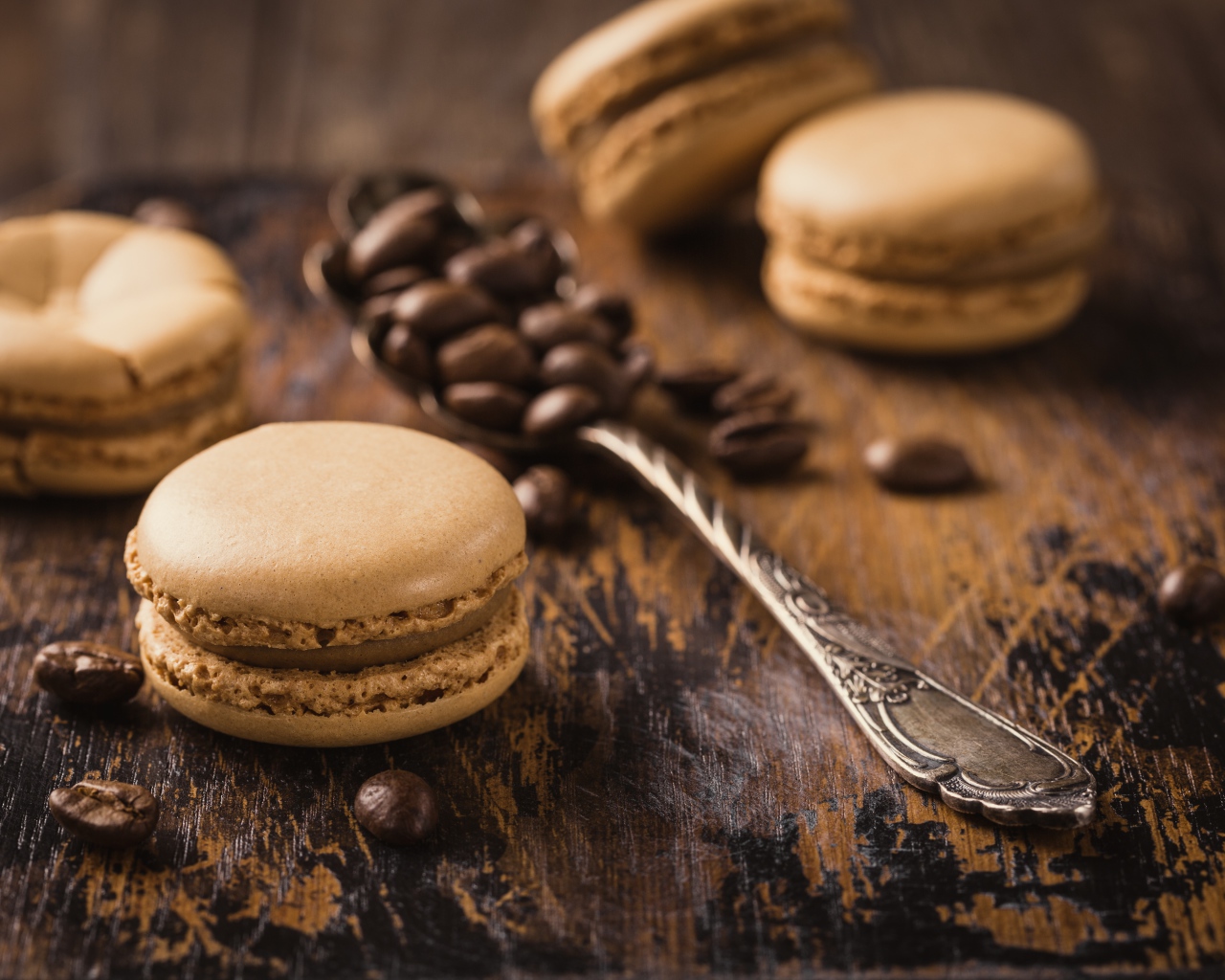 Печенье макарон на столе с ложкой и кофейными зернами