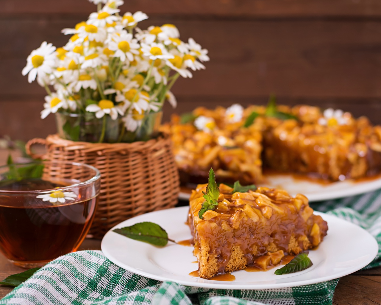 Пирог на столе с чаем и букетом ромашек