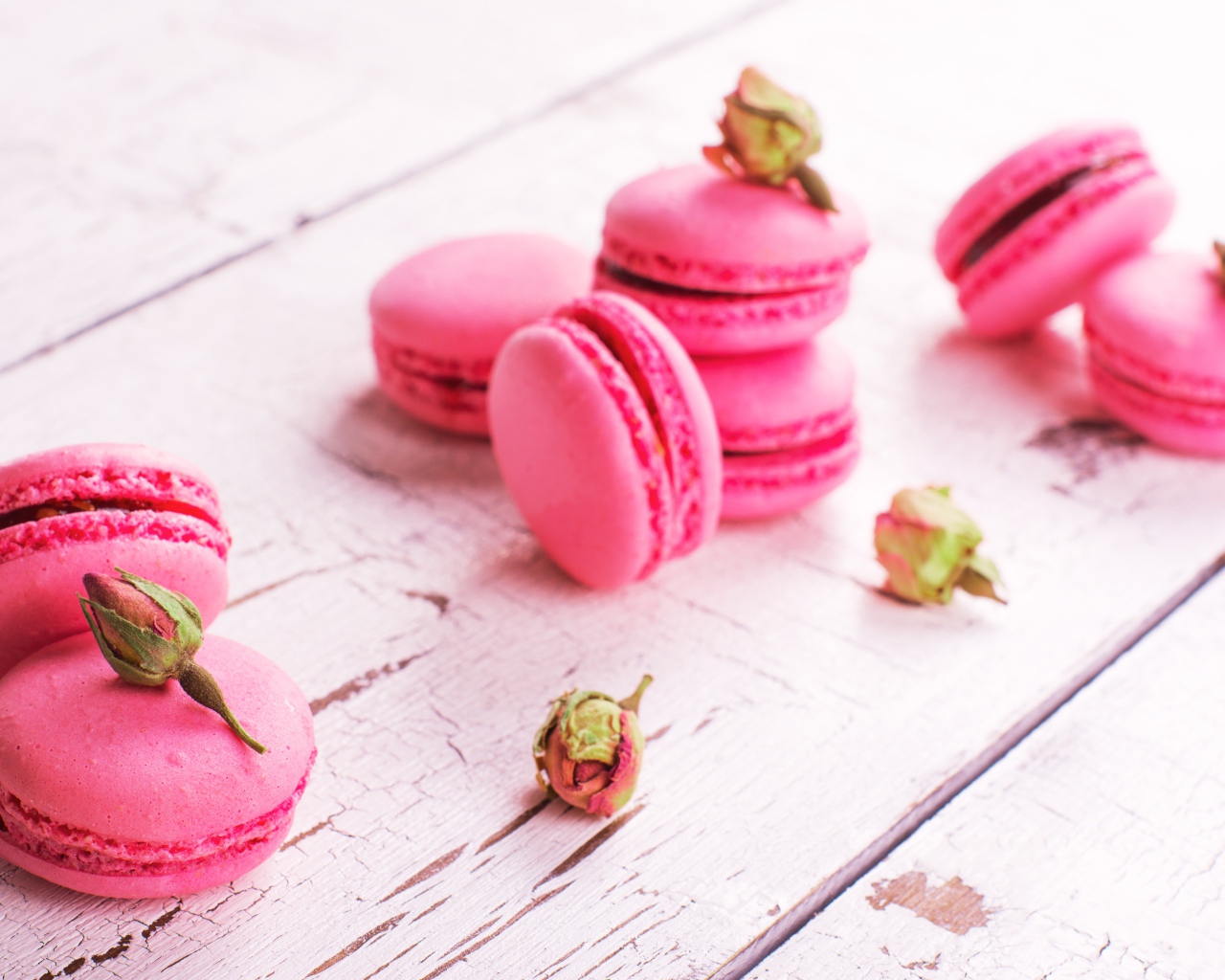 Розовый десерт макарон на столе с сухими розами