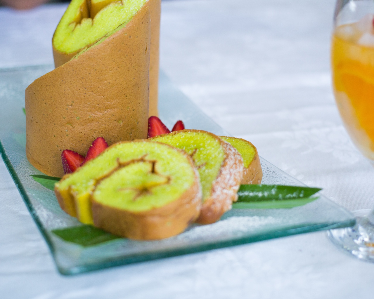 Рулет с сахарной пудрой и клубникой на столе