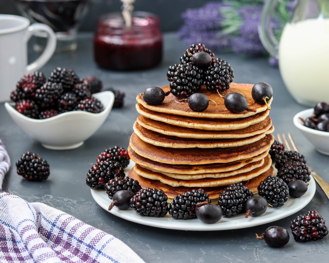 Румяные оладьи на тарелке с ягодами черники и смородины