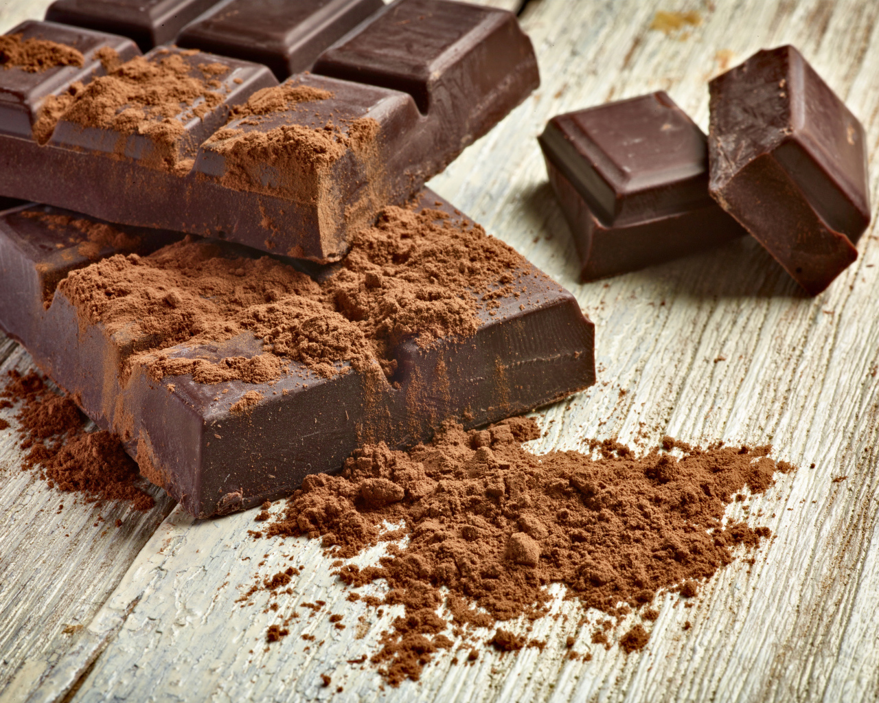 Куски шоколада с какао на деревянном столе 