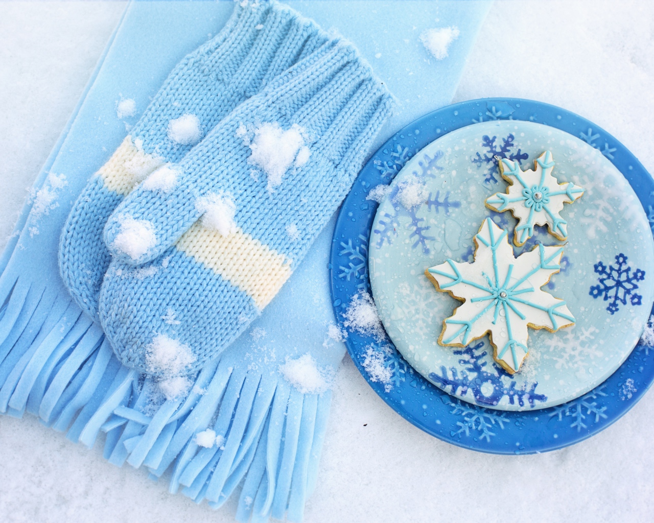 Печенье снежинки на снегу с шарфом и рукавицами