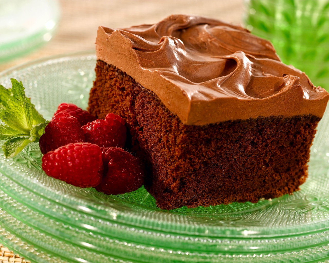 Бисквит с кремом и свежей малиной на тарелке