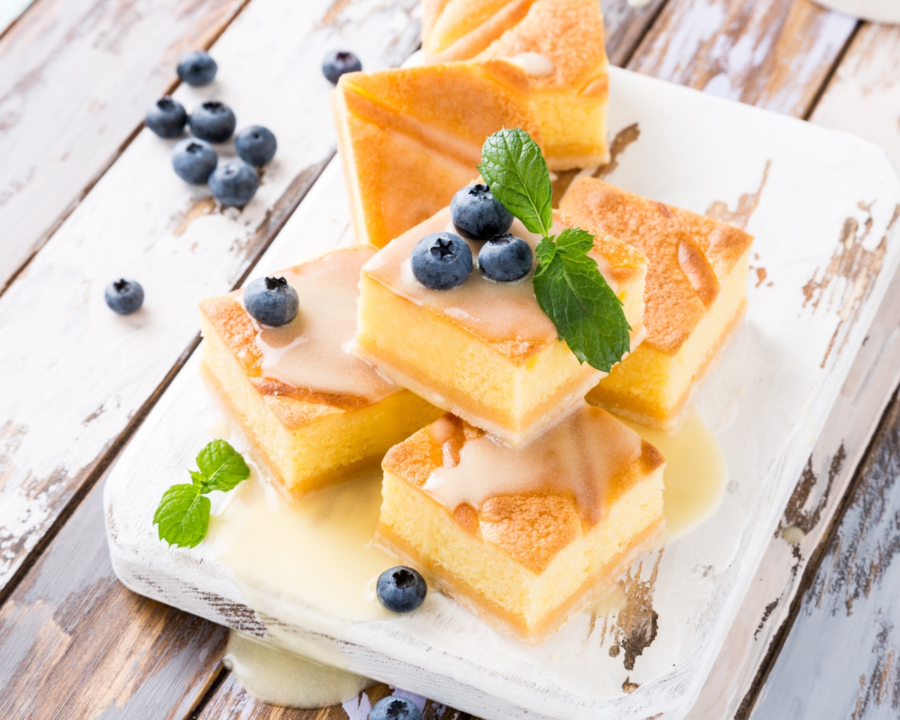 Бисквитные пирожные с сиропом и ягодами черники на столе