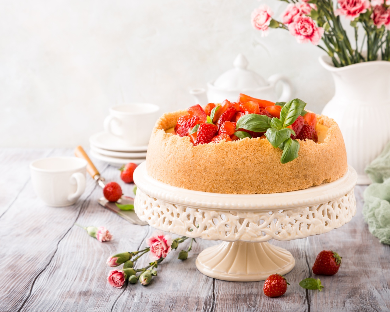 Песочный пирог с клубникой на столе с цветами гвоздики