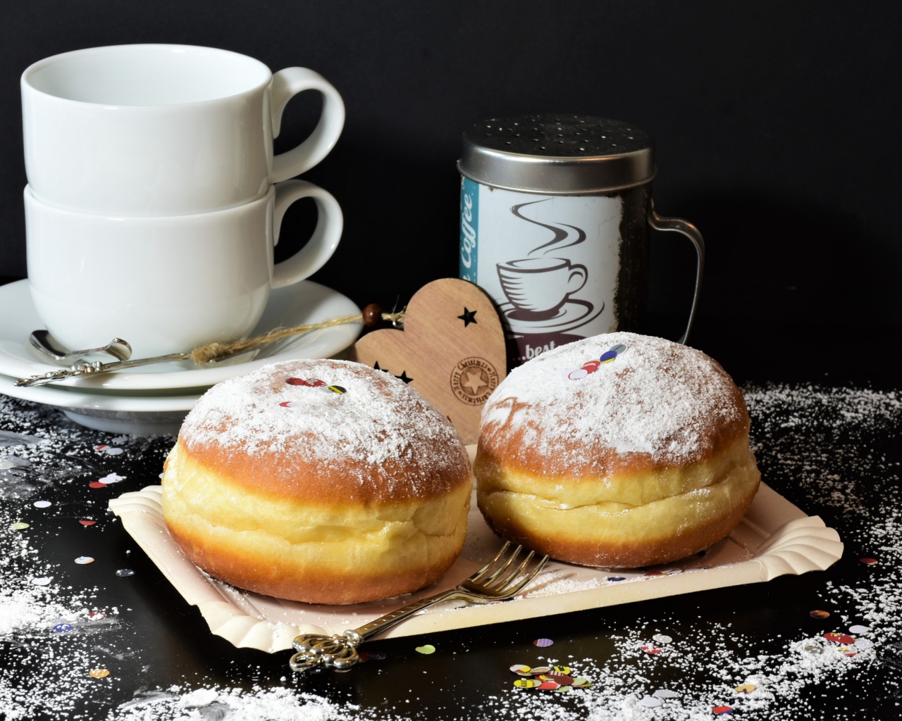 Два пончика с сахарной пудрой на черном фоне с белыми чашками