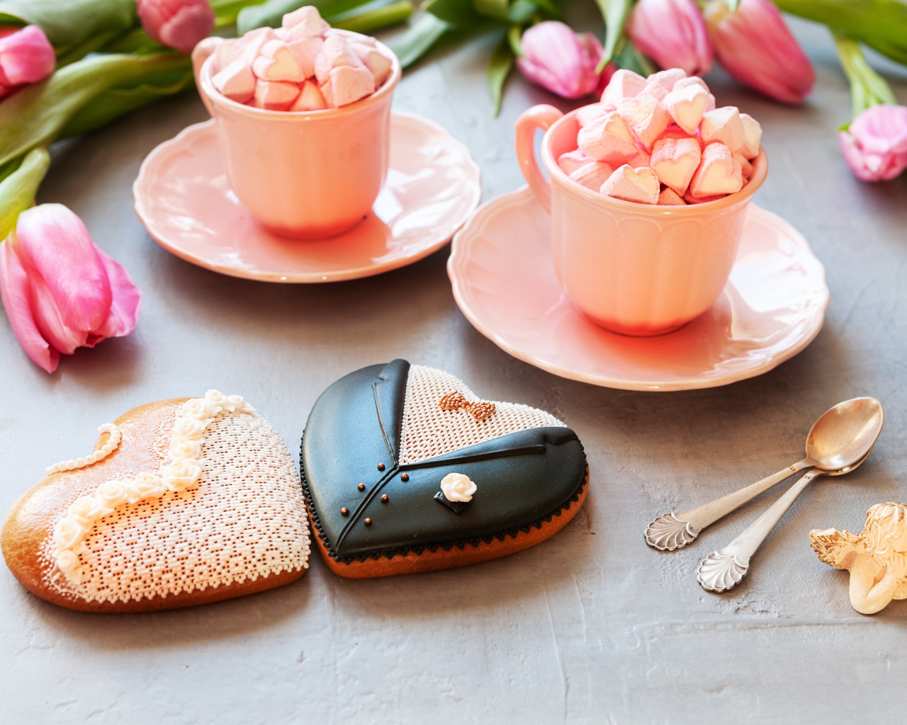 Две розовые чашки с маршмеллоу на сером фоне с печеньем и тюльпанами