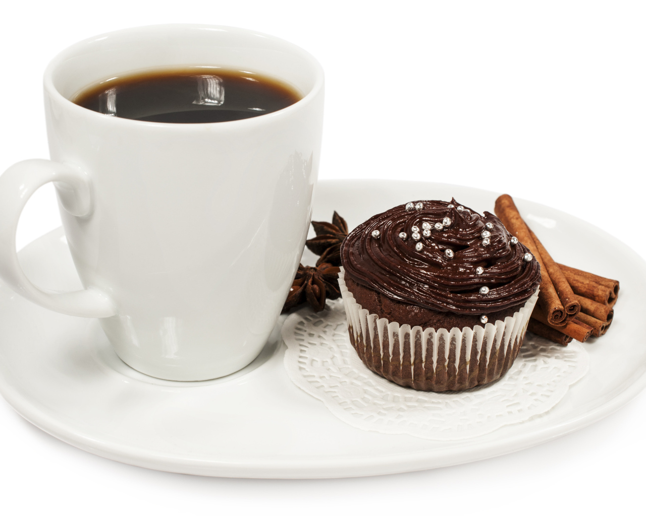 Чашка кофе на белой тарелке с кексом и корицей