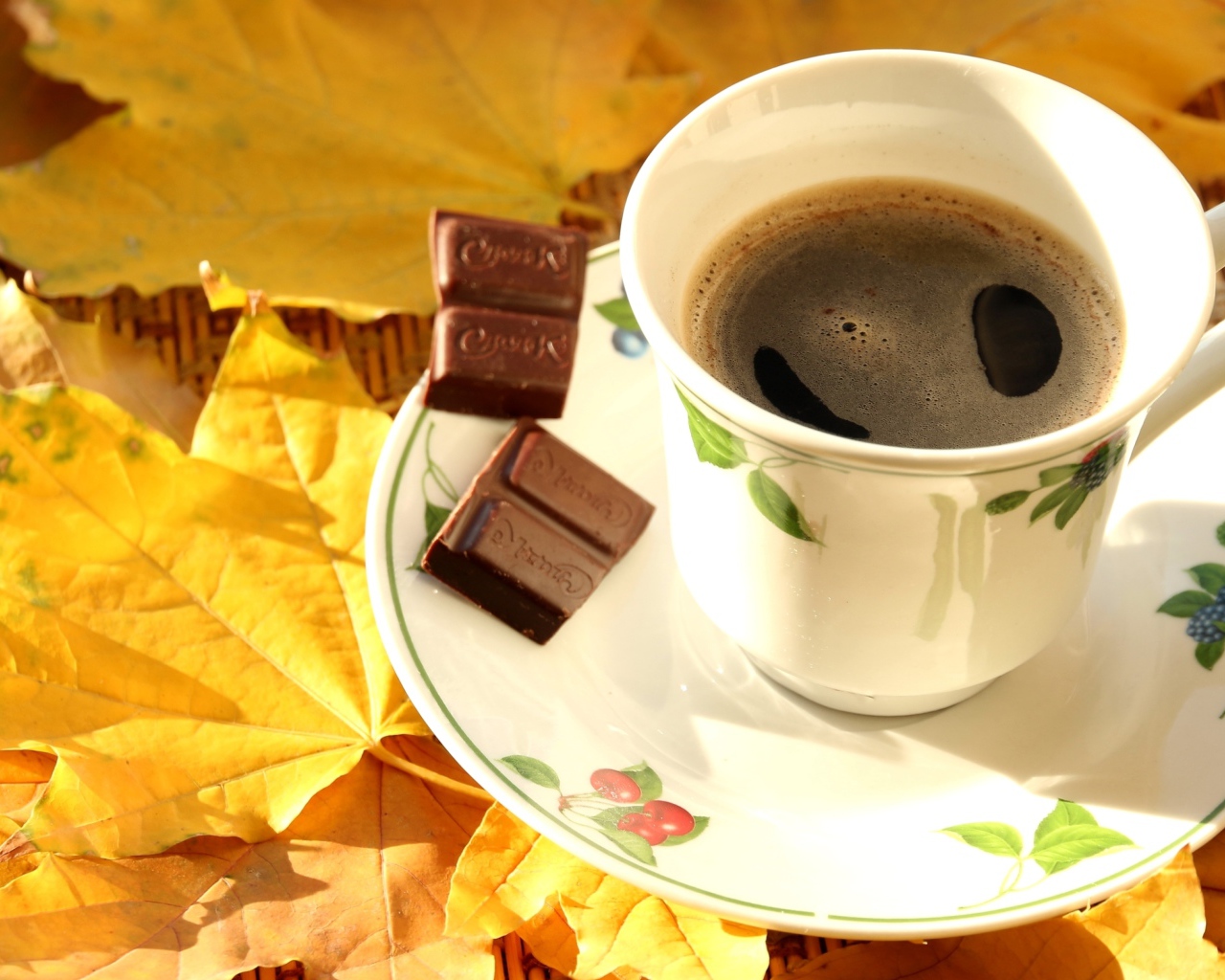 Чашка кофе с шоколадом стоит на желтых осенних листьях 