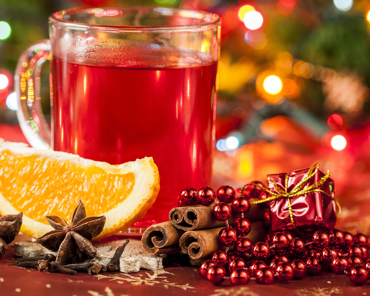 Чашка горячего чая на столе с корицей, бадьяном и кусочком апельсина 