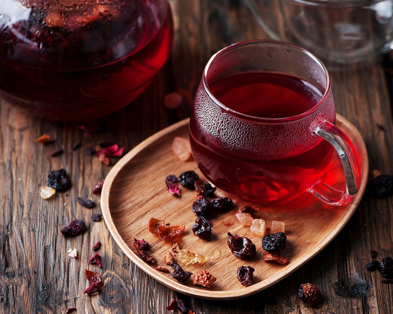 Стеклянная чашка горячего красного чая с сухофруктами 