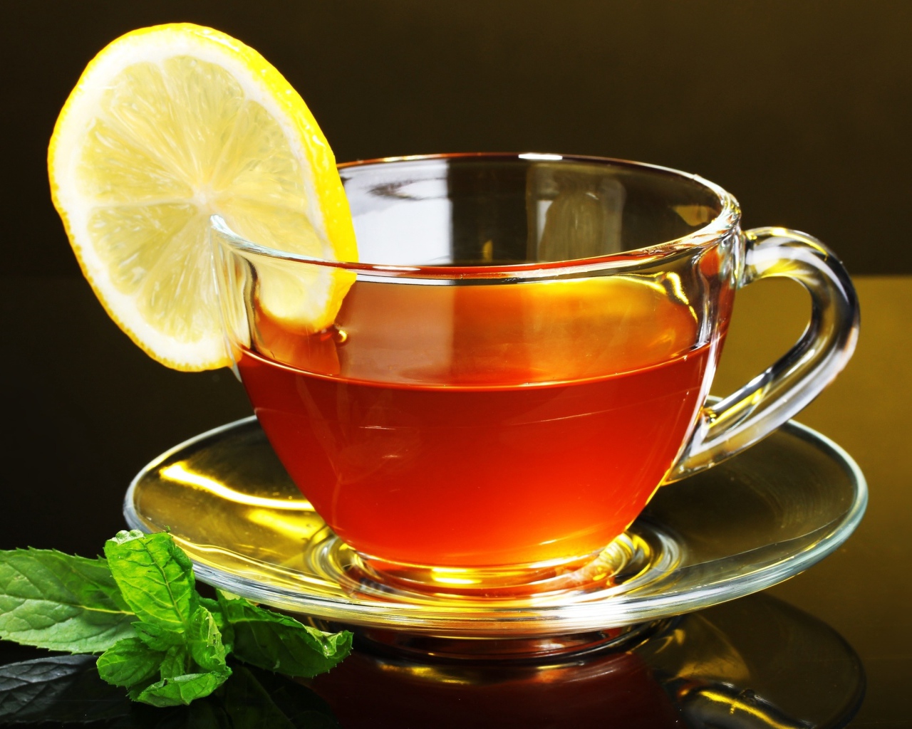 Стеклянная чашка чая с лимоном и листьями мяты