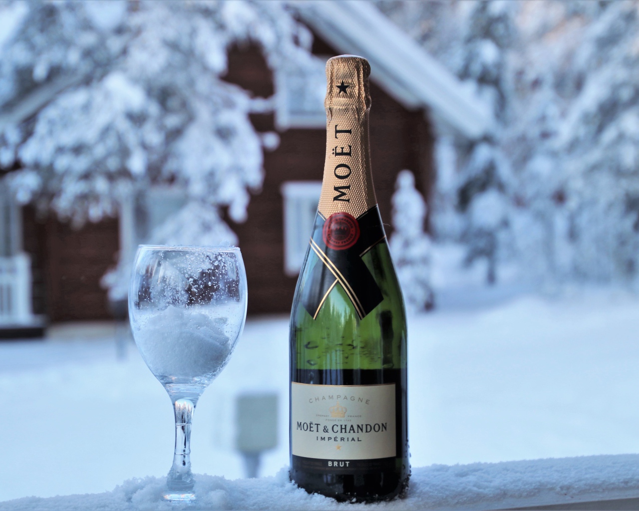 Бокал на снегу с бутылкой шампанского 