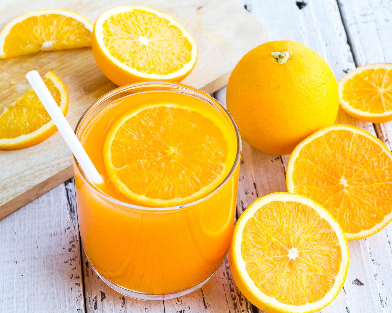 Стакан апельсинового сока на столе со свежими апельсинами на столе