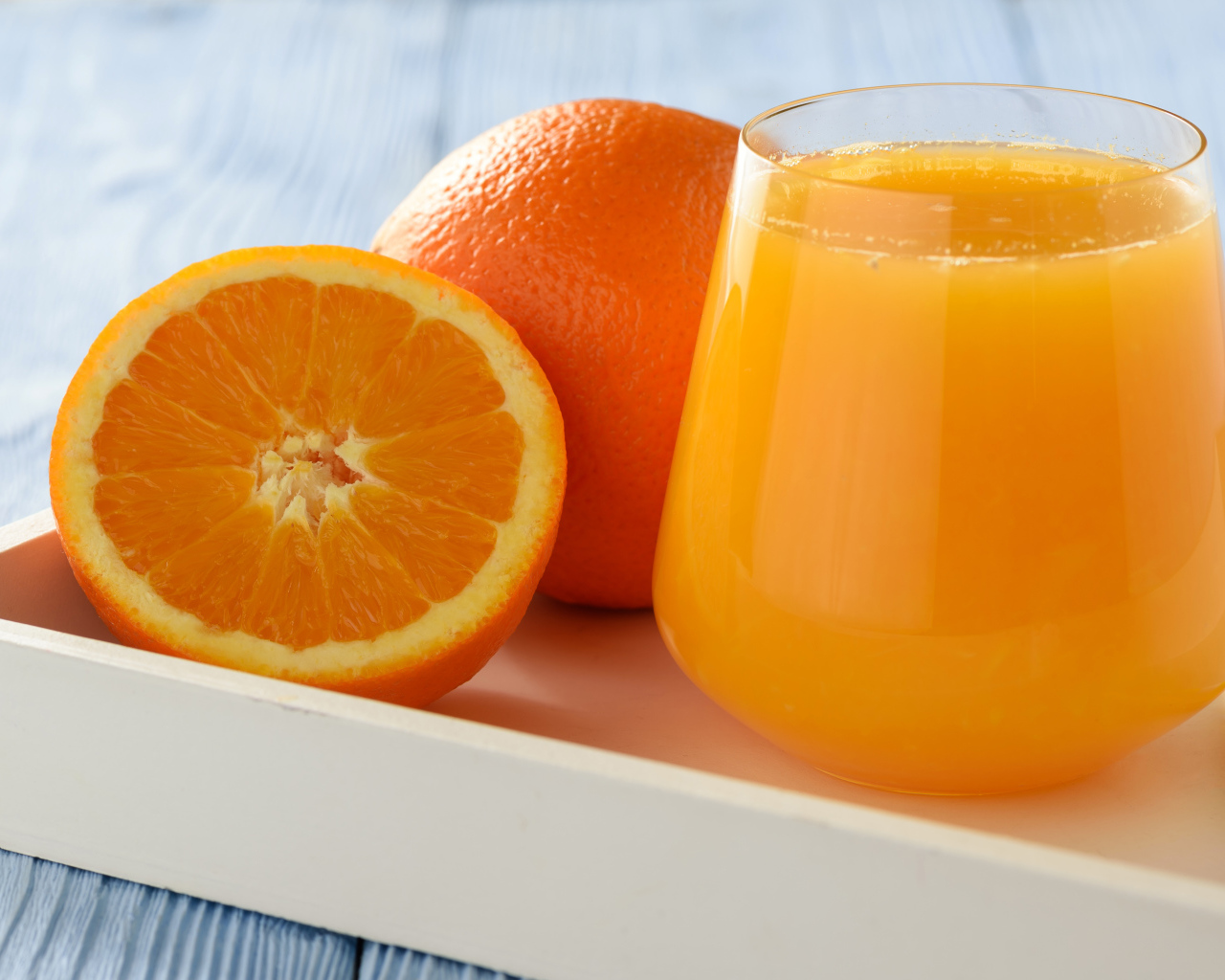 Стакан апельсинового сока на столе с апельсином 