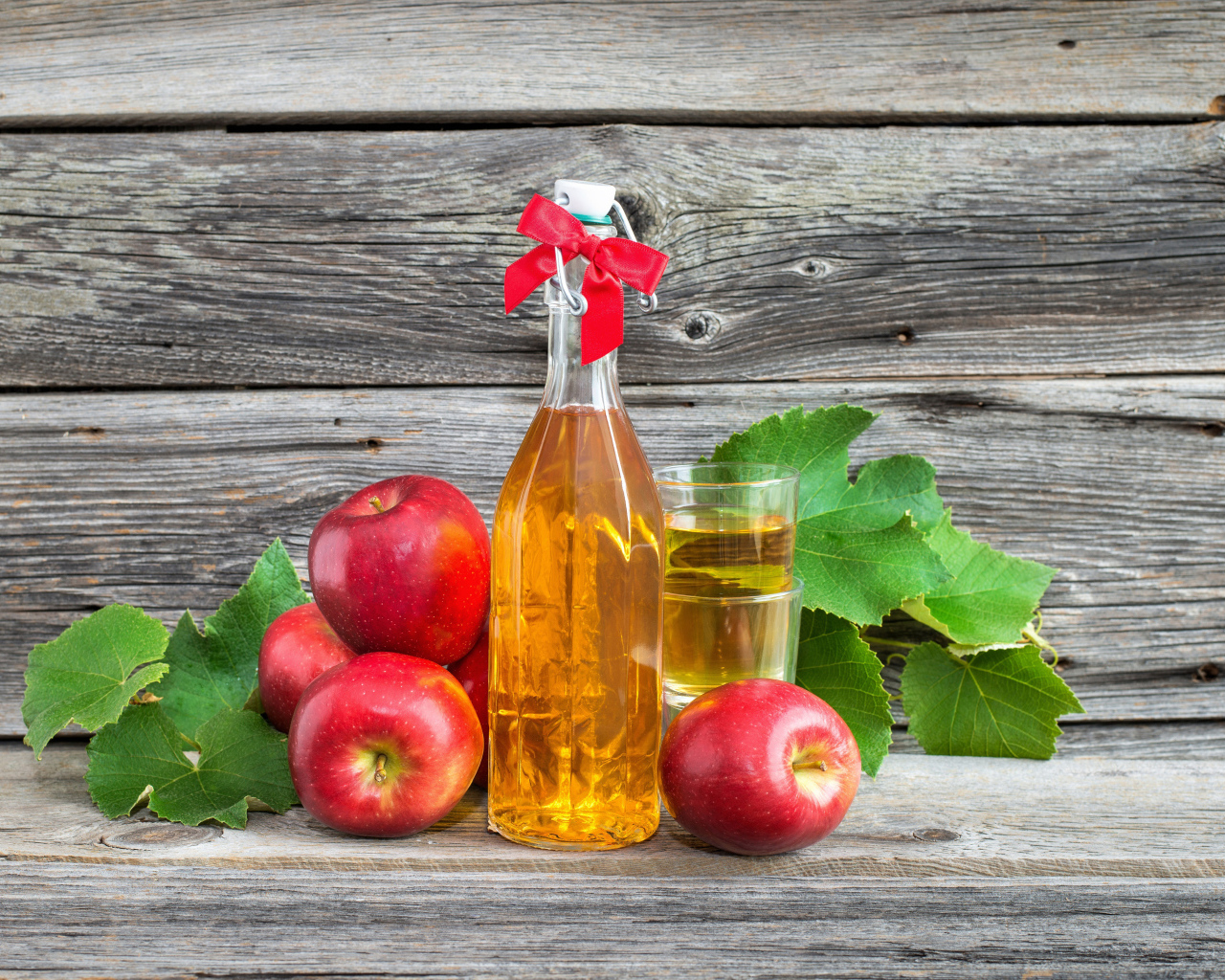 Яблочный сок на столе с красными яблоками