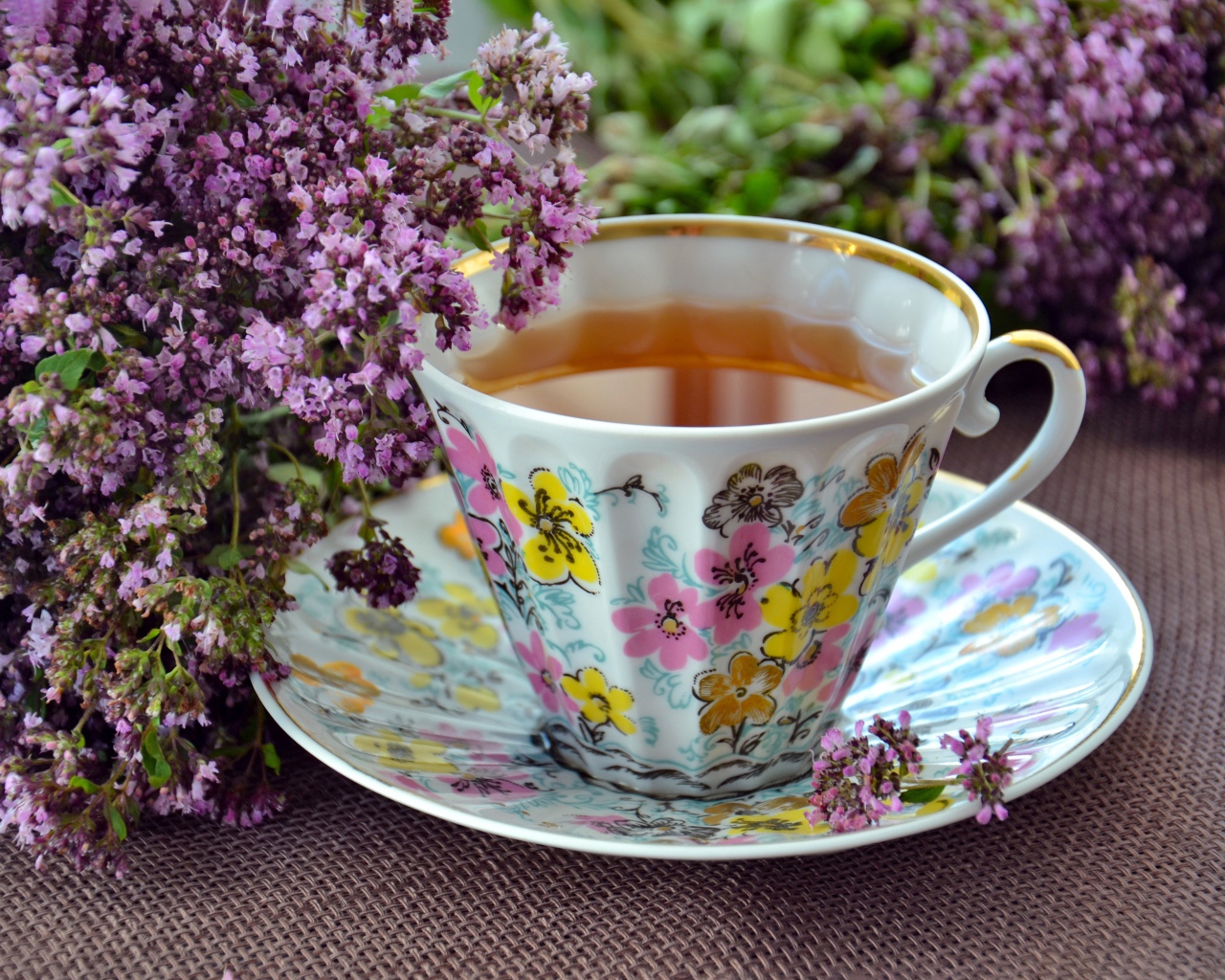 Красивая чашка чаю с цветами мяты на столе