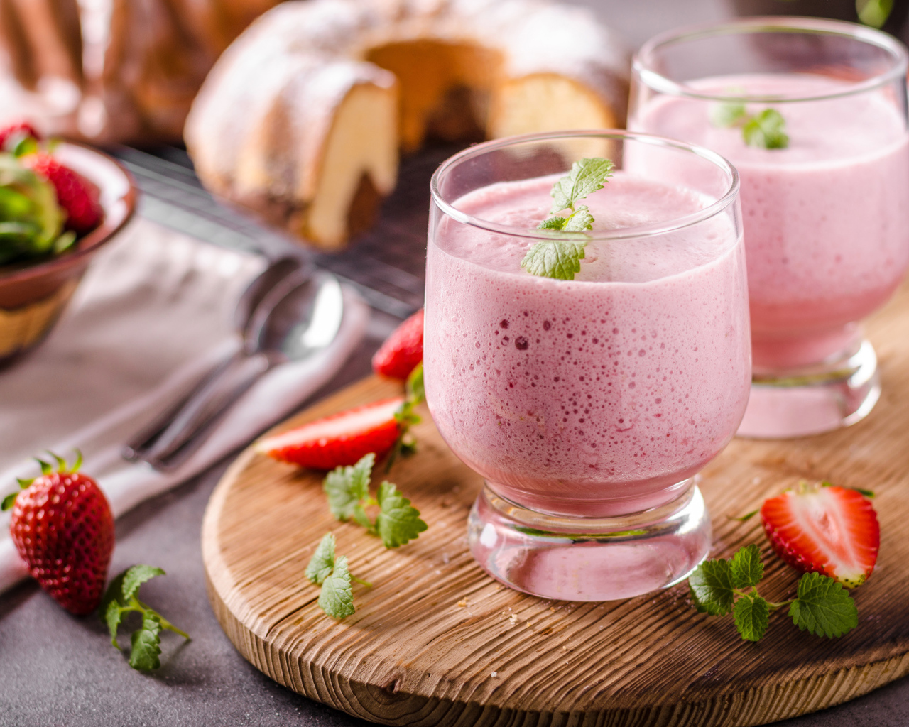 Ягодное смузи в стаканах на столе с клубникой