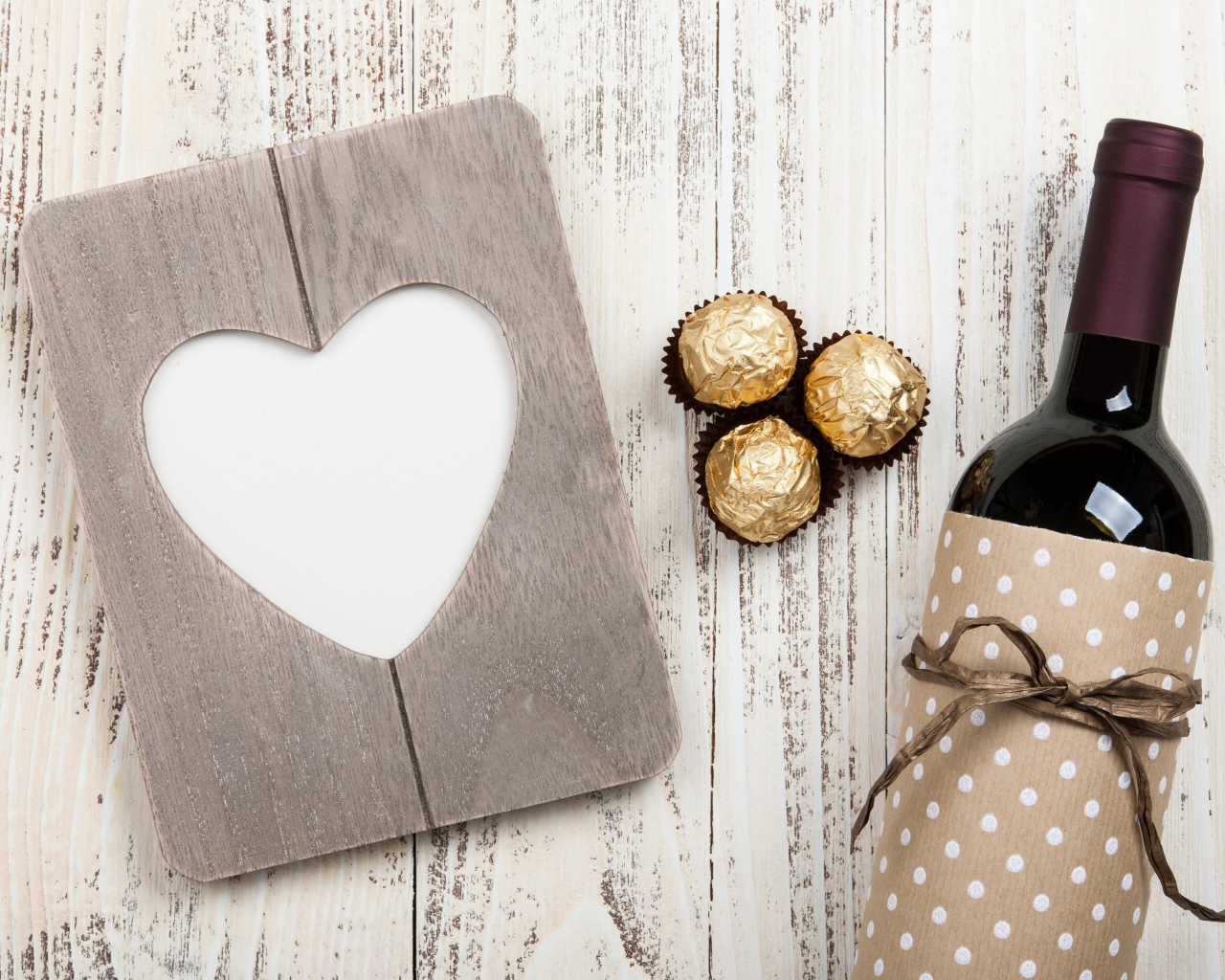 Бутылка вина на столе с конфетами и сердцем 