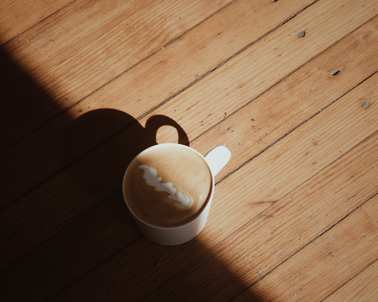 Чашка капучино с рисунком на деревянном столе