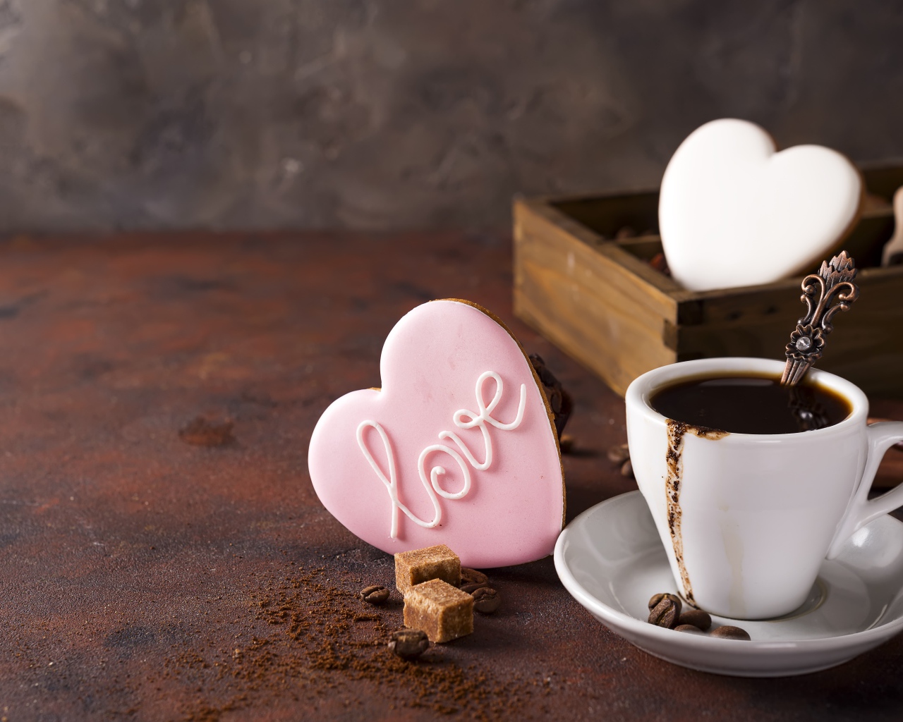 Чашка кофе на столе с сахаром и печеньем в форме сердца 