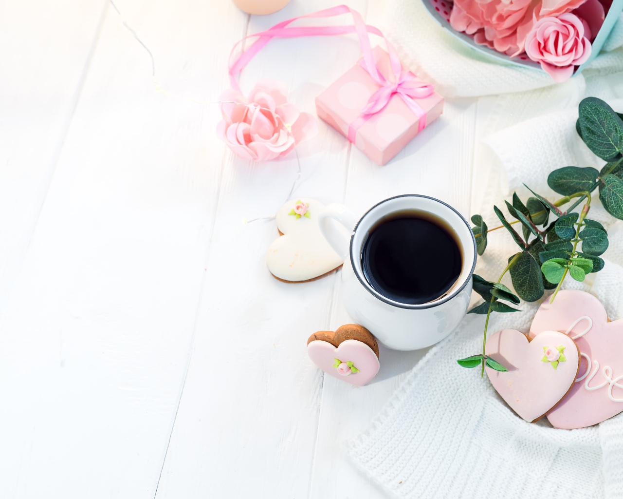 Чашка кофе на столе с печеньем в форме сердца и подарком