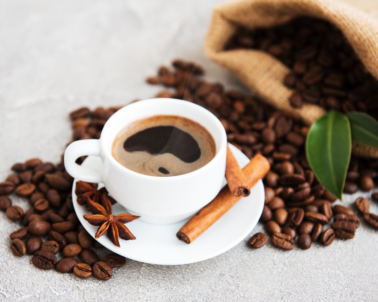 Чашка кофе с корицей, бадьяном и кофейными зернами