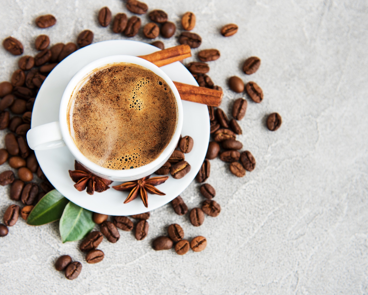 Чашка кофе с кофейными зернами на столе с корицей и бадьяном