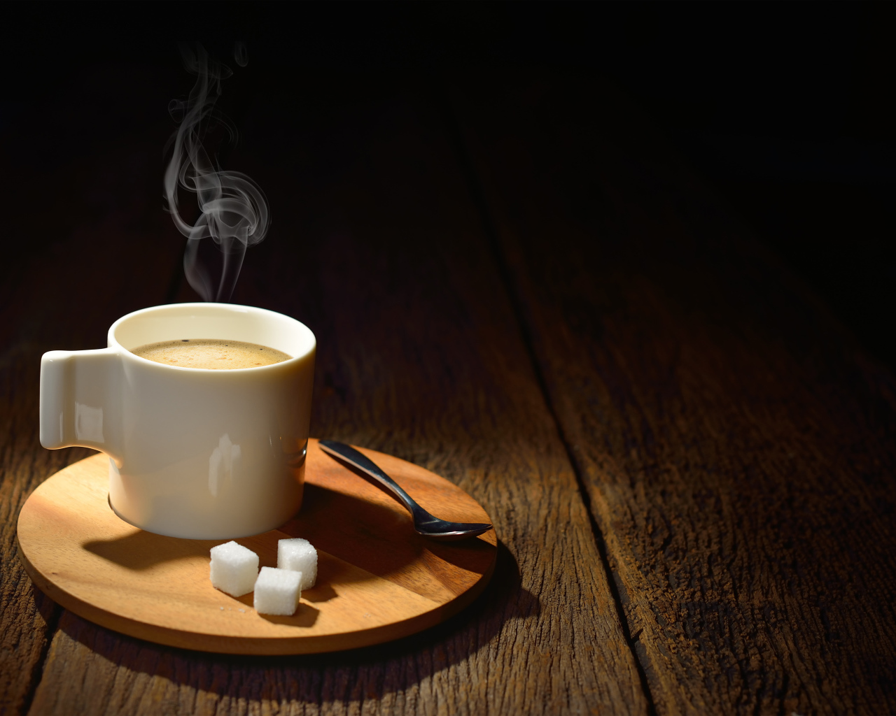 Чашка горячего кофе на столе с сахаром
