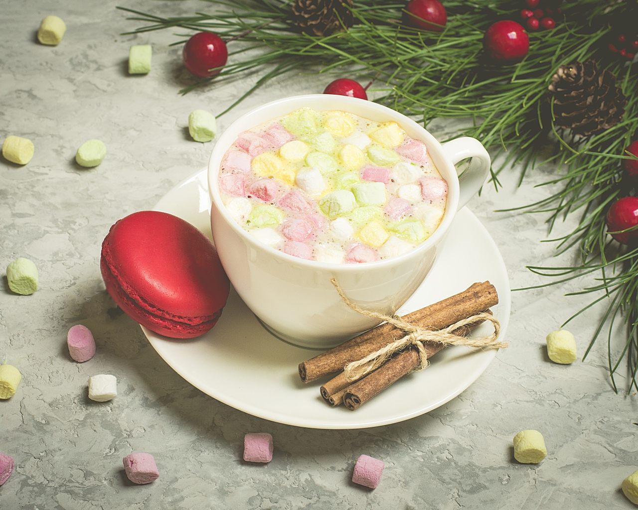 Напиток с маршмелоу на блюдце с макаруном и корицей