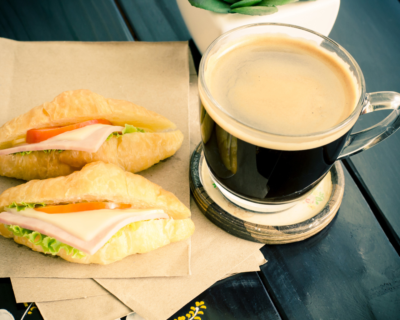 Стеклянная чашка кофе на столе с сэндвичами