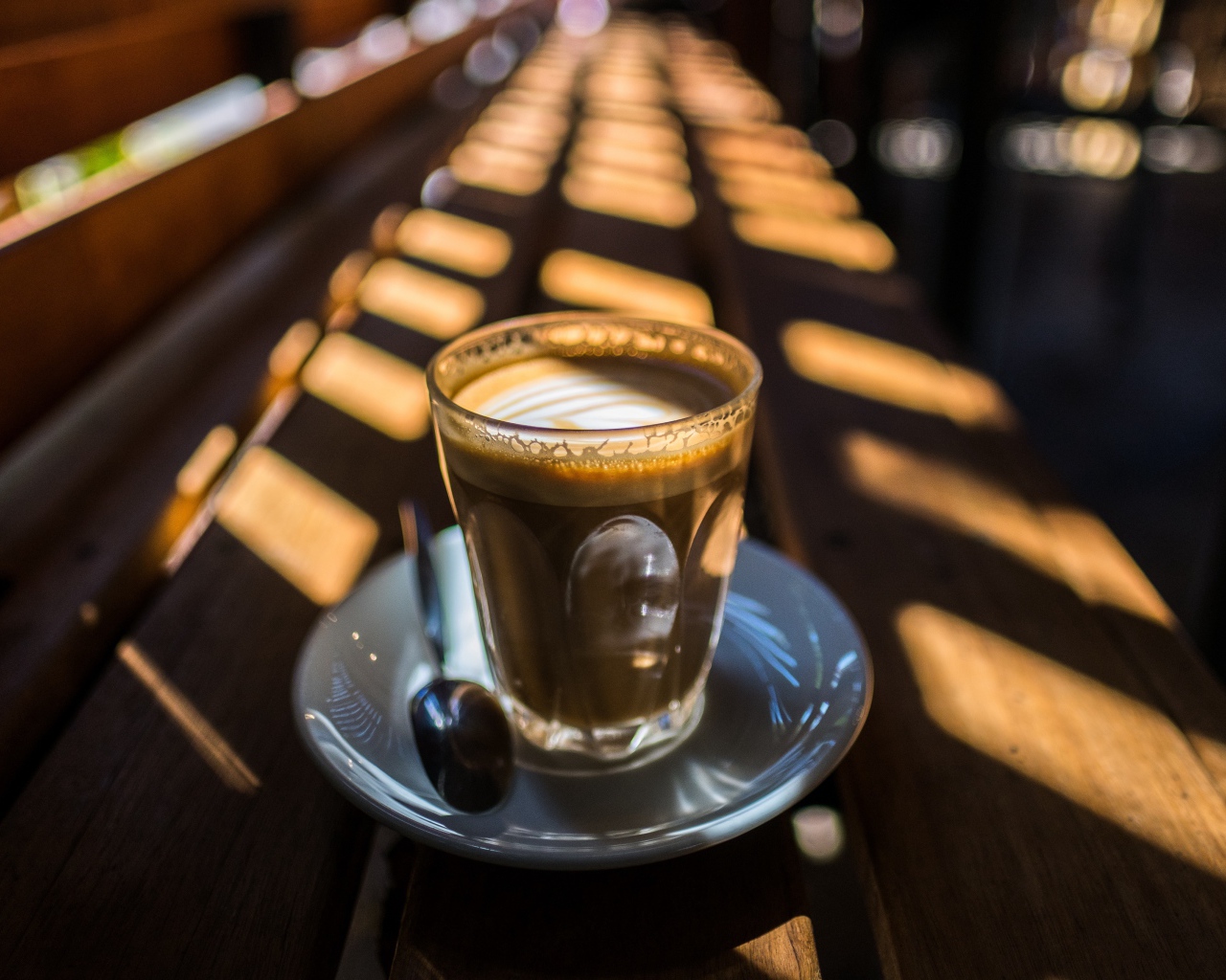 Стакан с кофе стоит на деревянном лавке