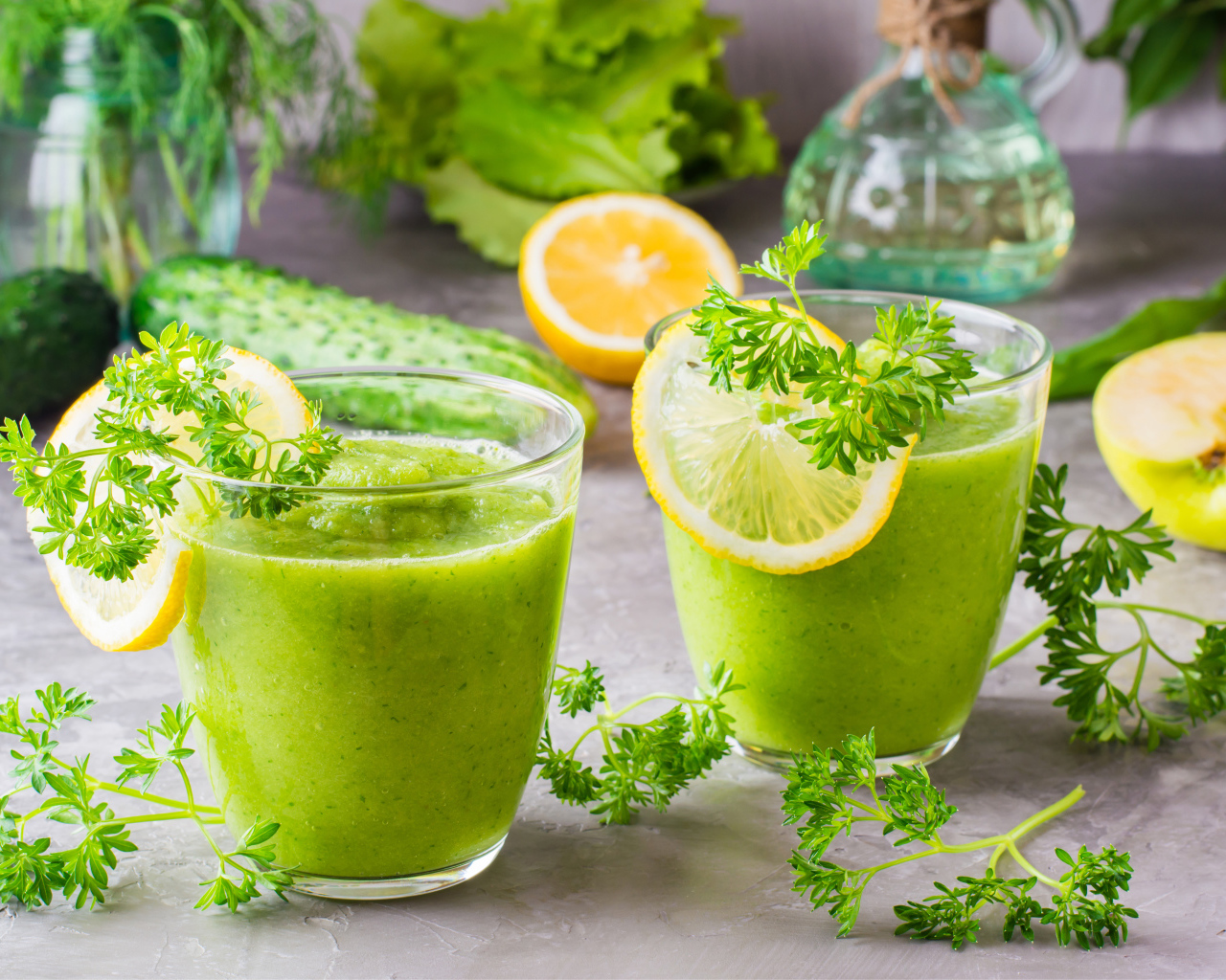 Зеленый смузи в стаканах с кусочками лимона и петрушкой