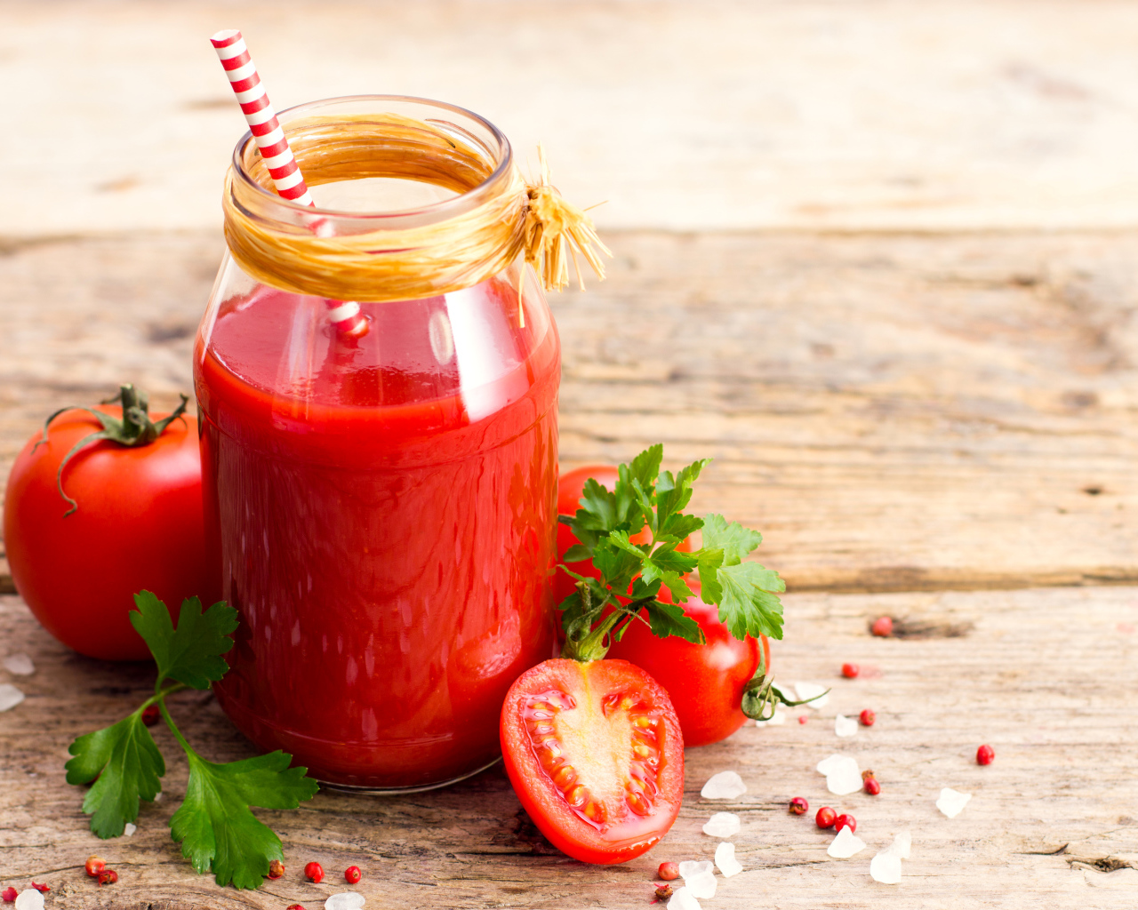 Банка томатного сока на столе с помидорами и петрушкой