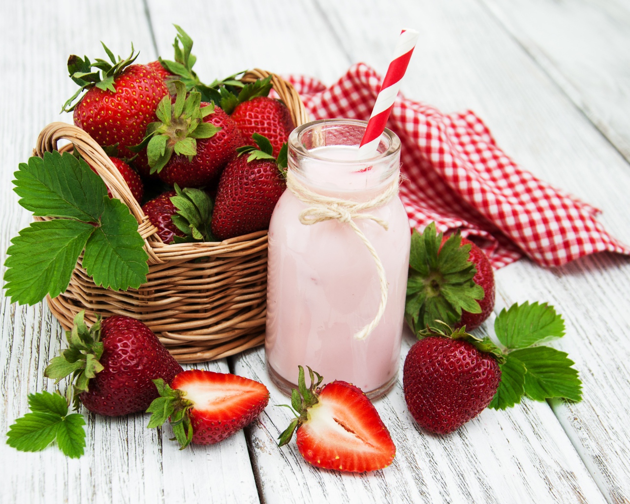 Банка с коктейлем на столе с ягодами клубники