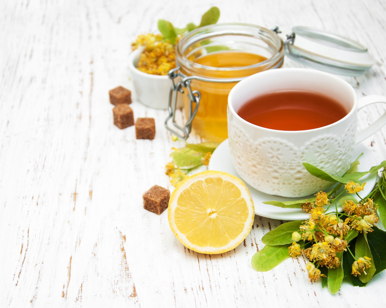 Липовый чай на столе с медом, лимоном, и сахаром